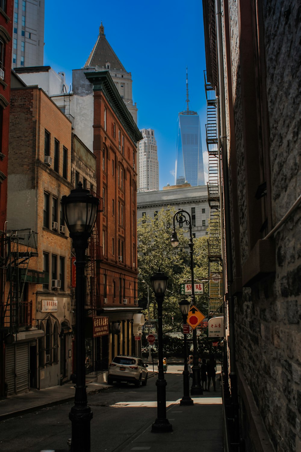 uma rua estreita da cidade com edifícios altos ao fundo