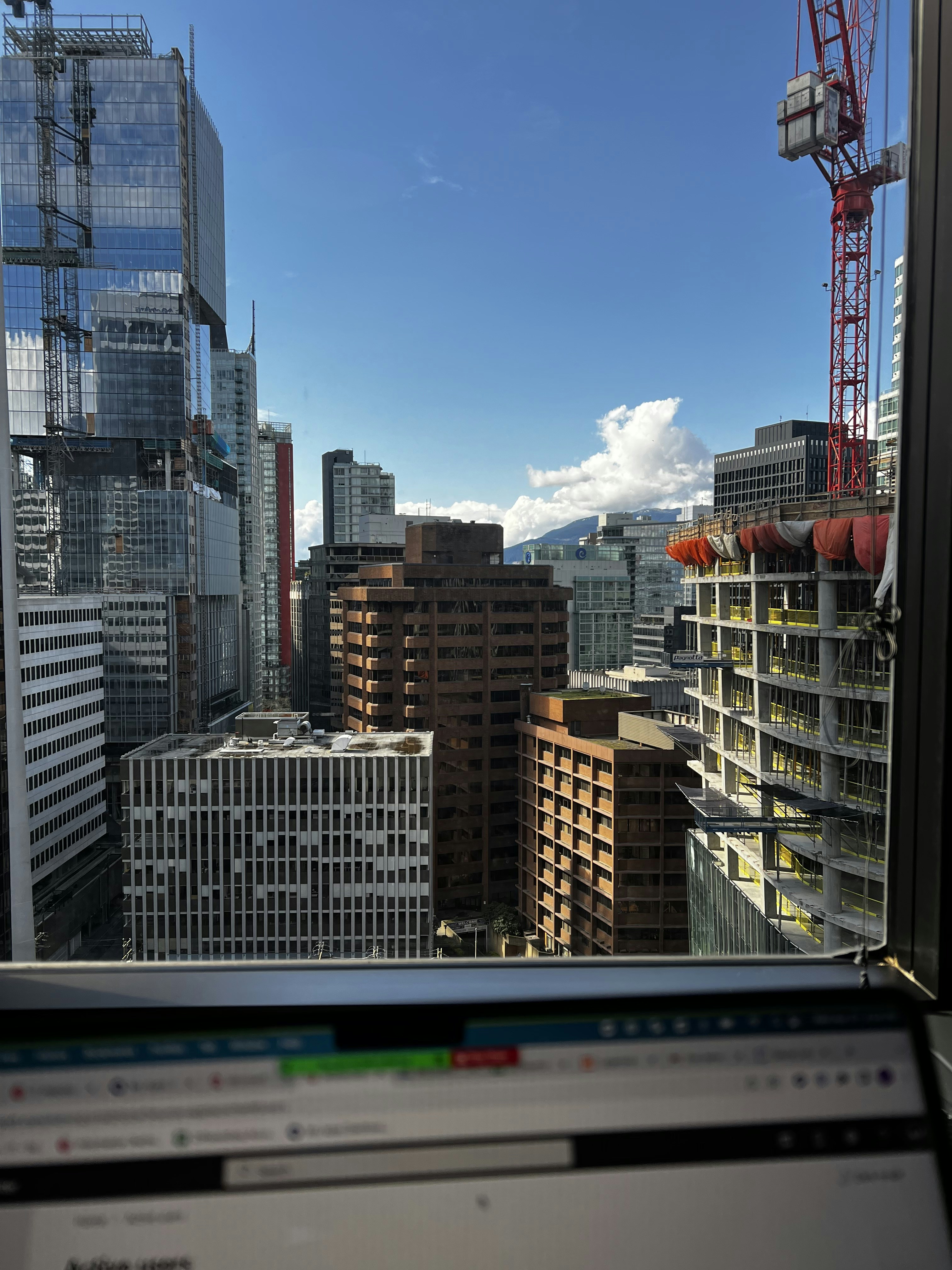 Modern skyscrapers and a construction crane tower over a city.