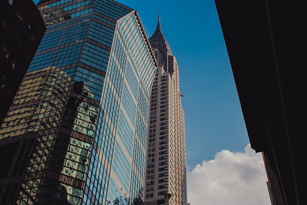 a view of skyscrapers from the ground looking up