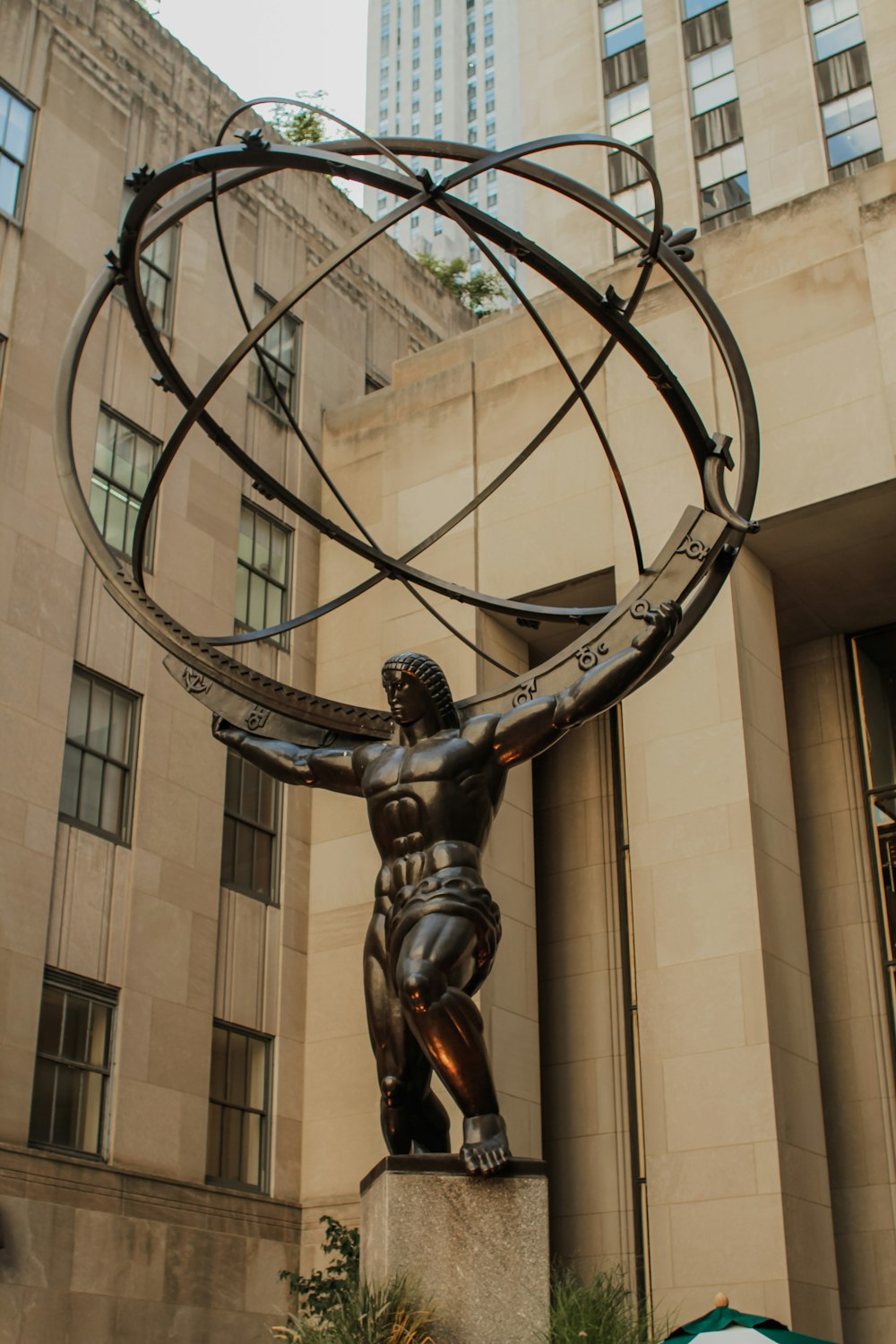 uma estátua de um homem segurando o mundo em suas costas
