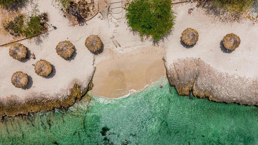 an aerial view of a sandy beach with green water