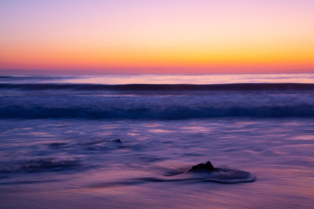 Eine Welle rollt bei Sonnenuntergang am Strand herein