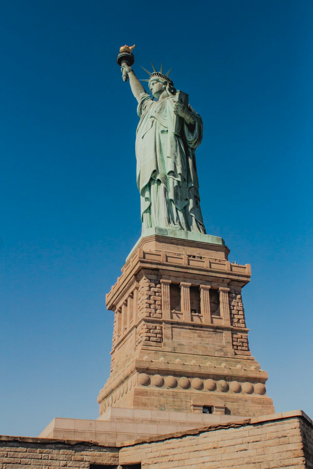 the statue of liberty stands tall against a blue sky