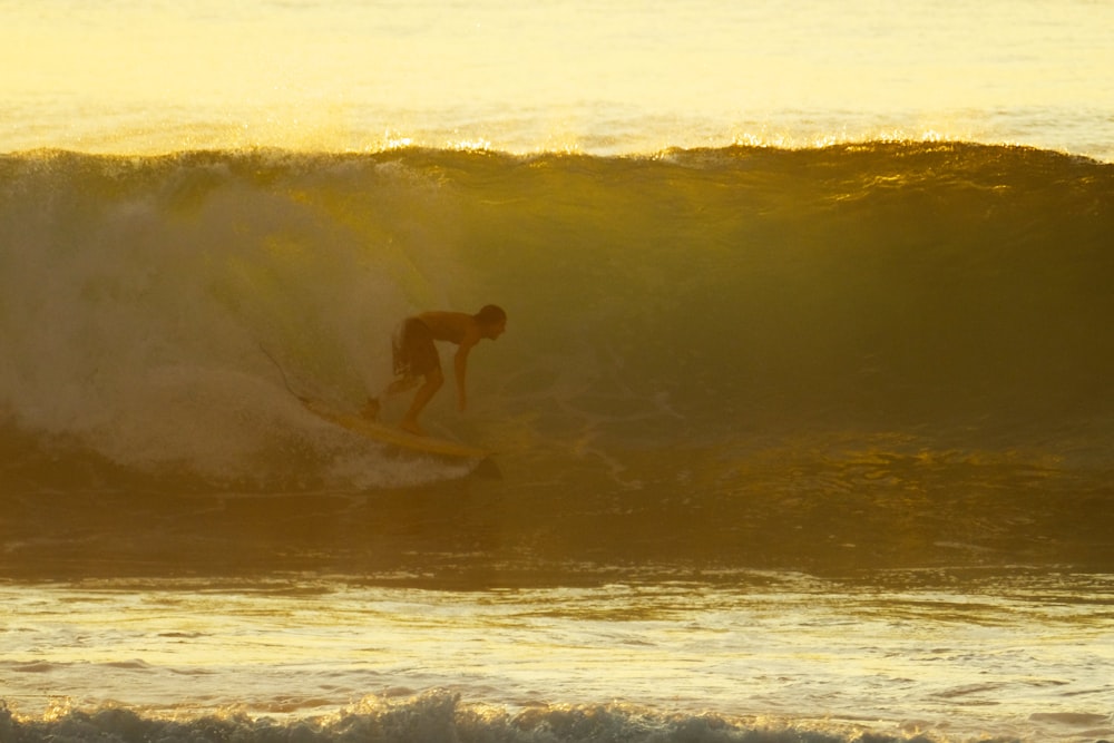 a man riding a wave on top of a surfboard