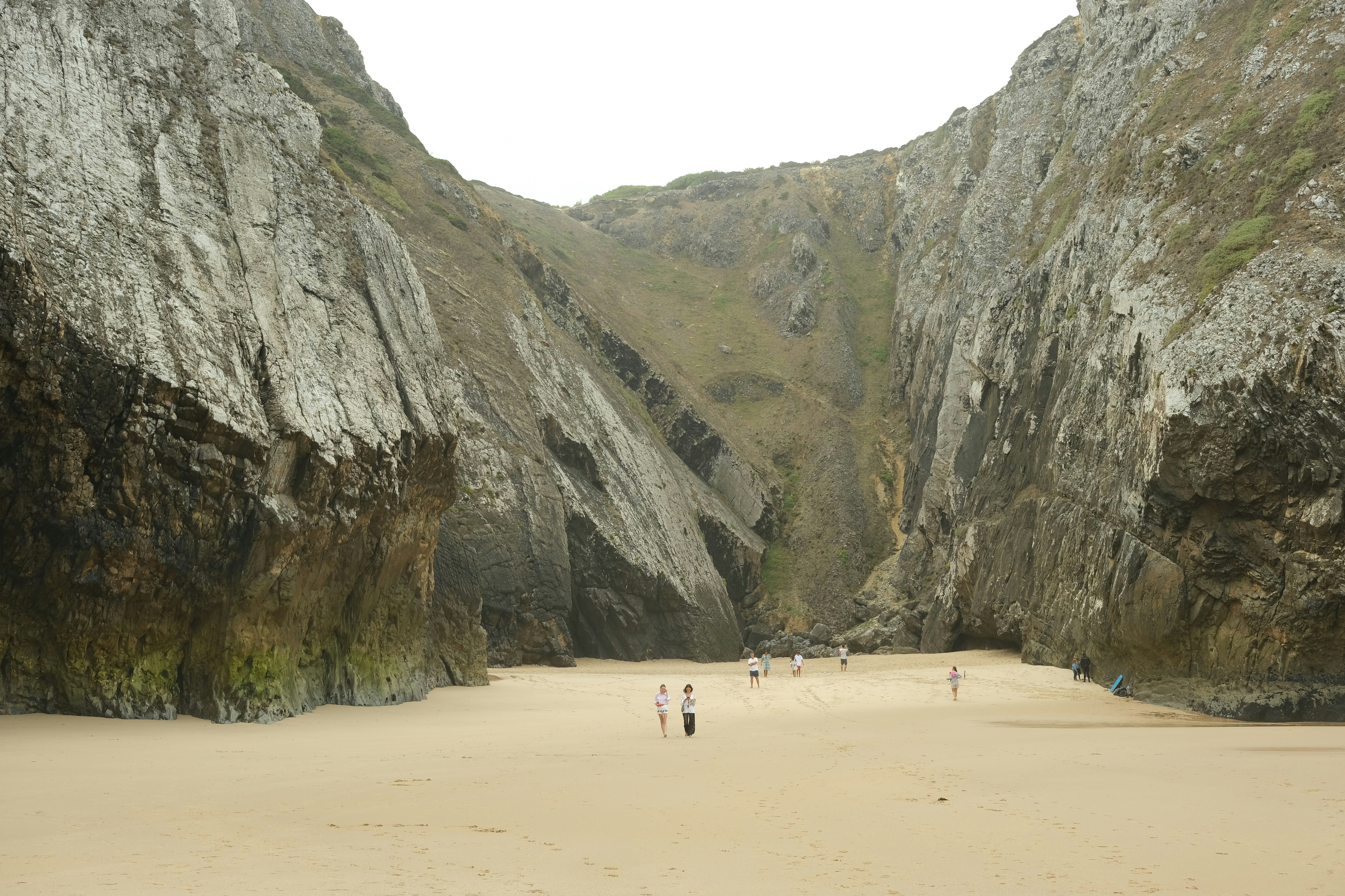 a group of people standing on top of a sandy beach