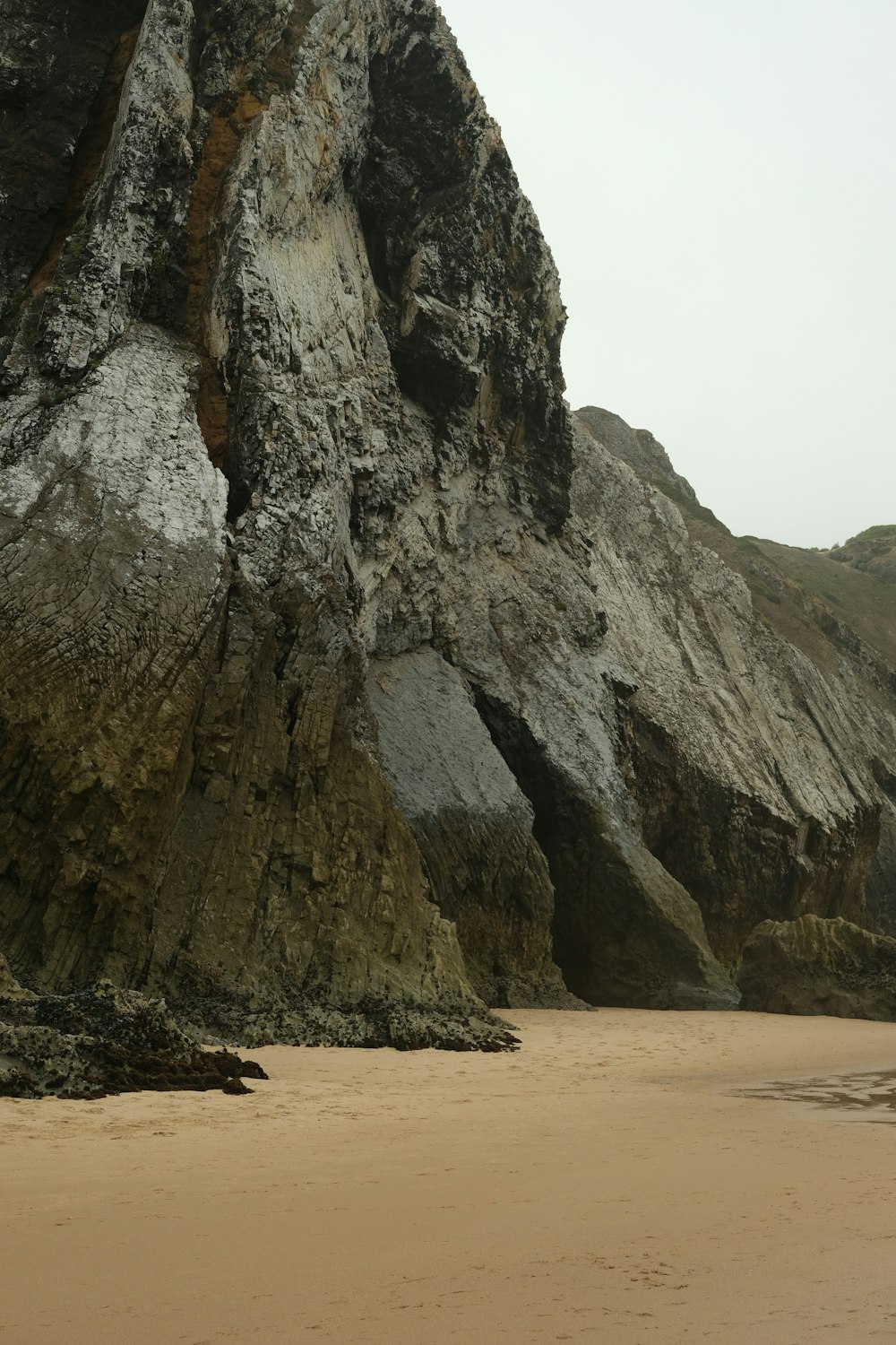 a large rock formation on a sandy beach