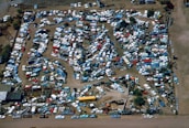 Wide view of a busy scrapyard with stacked vehicles and metal scraps.