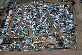 Wide view of a busy scrapyard with stacked vehicles and metal scraps.