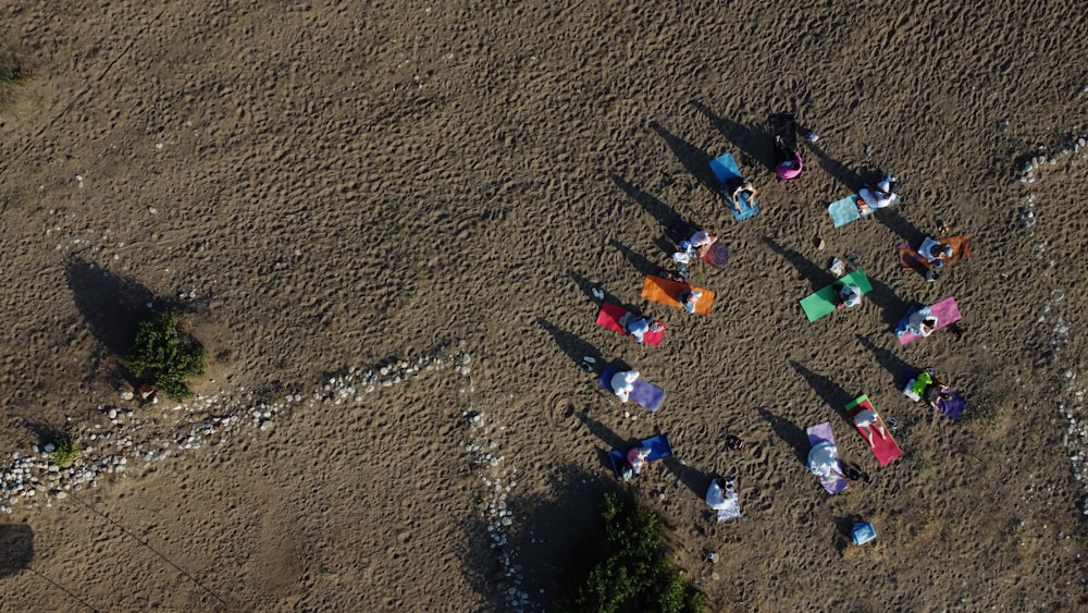 a group of people standing on top of a dirt field