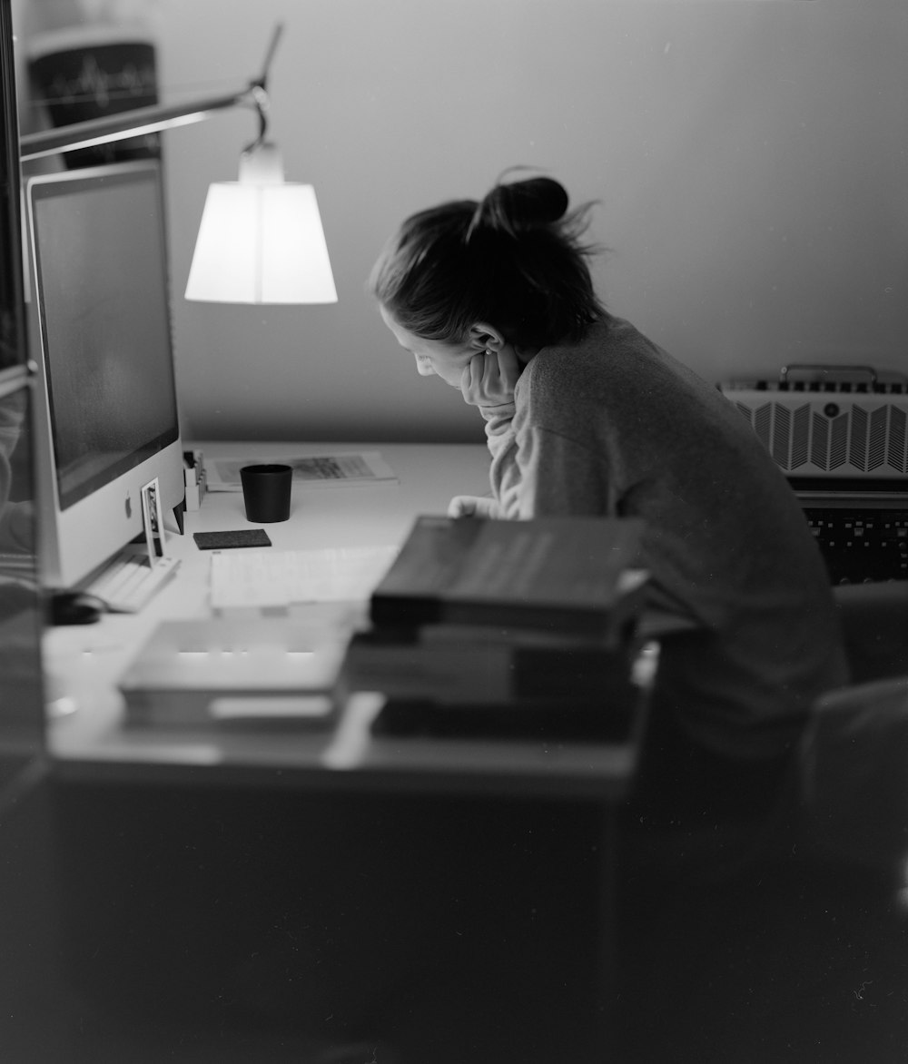 a woman sitting at a desk with a computer