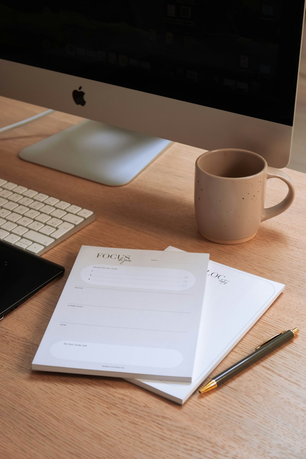 a cup of coffee and a notepad on a desk