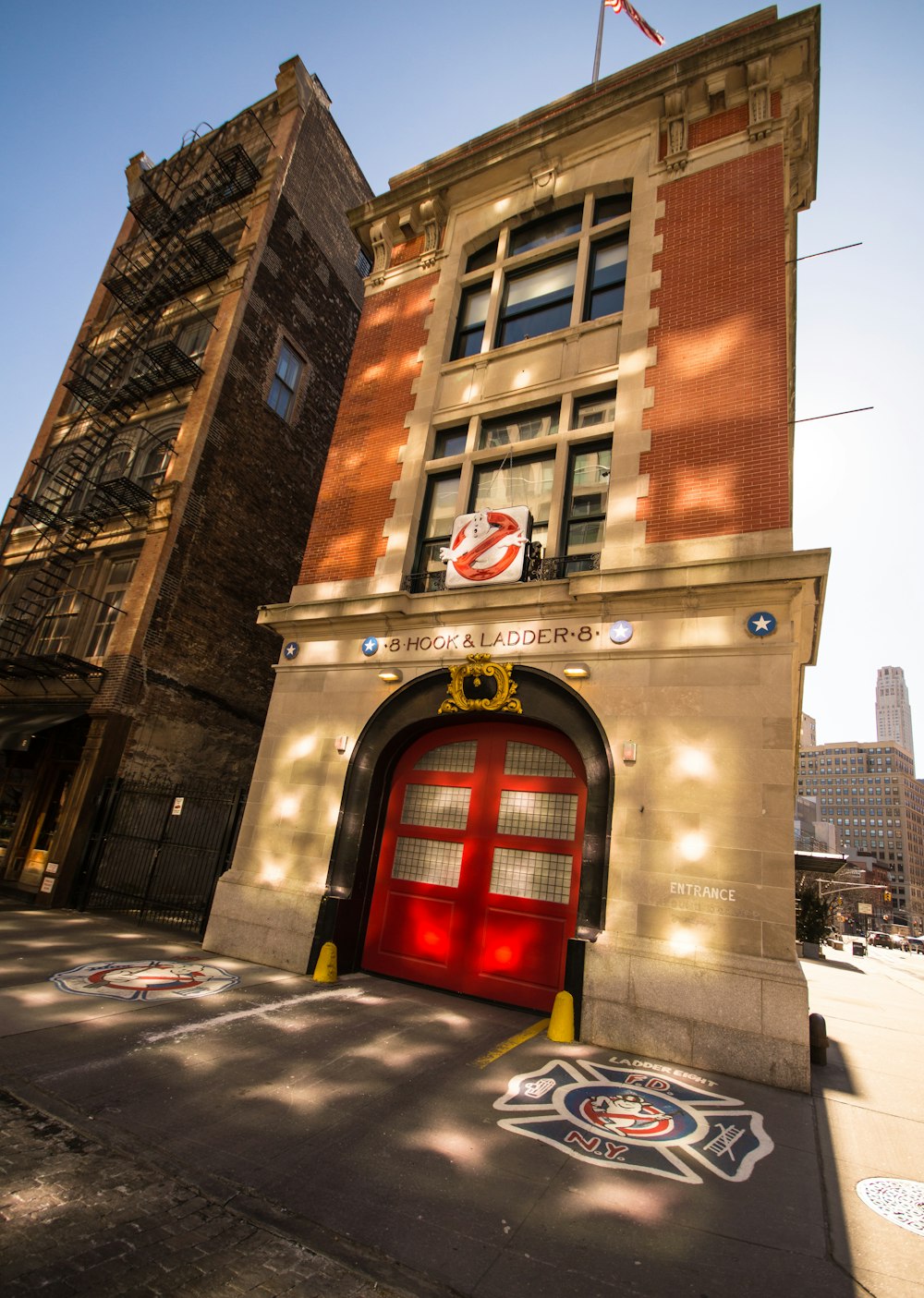 a tall building with a red door and a flag on top of it