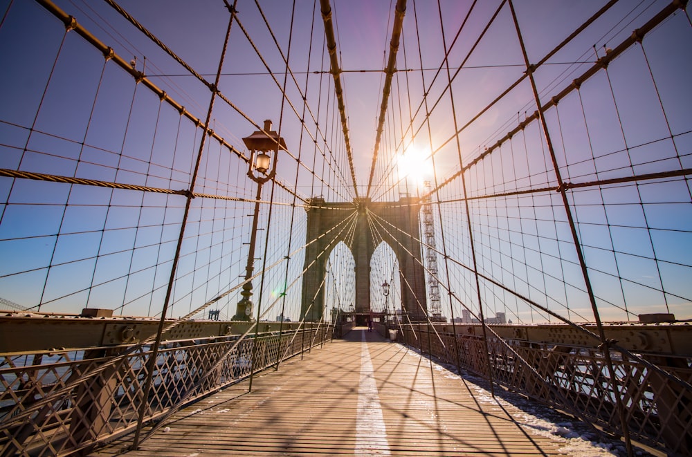 the sun is shining over the brooklyn bridge