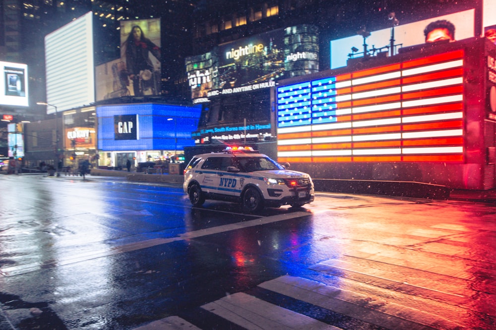 a police car driving down a city street at night