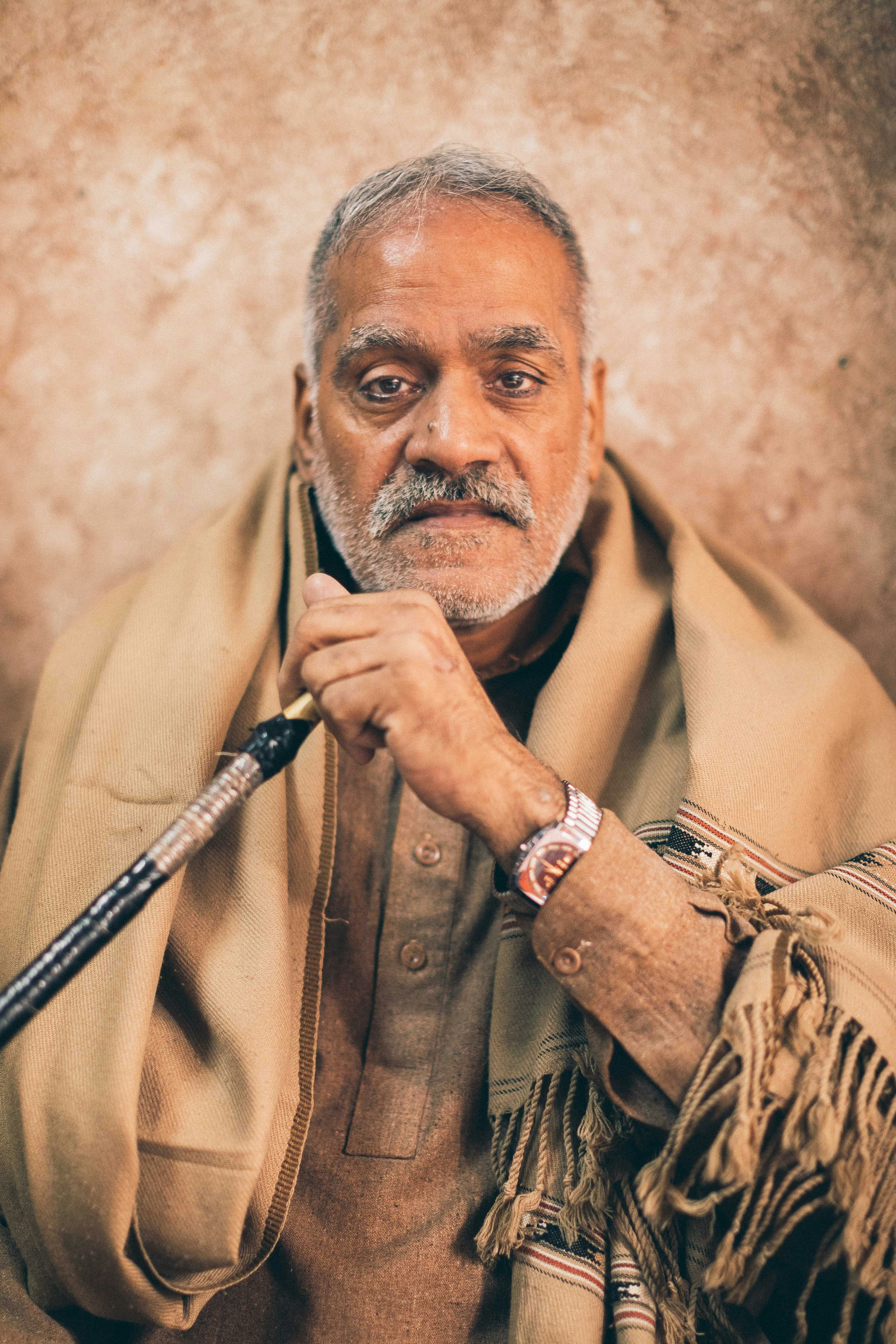 a man with a cane and a scarf around his neck