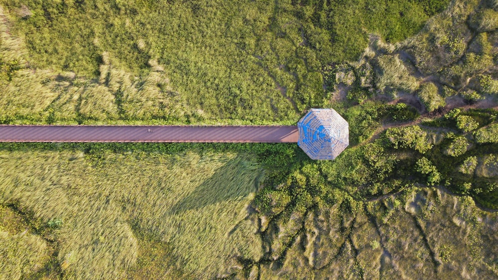an aerial view of a blue structure in the middle of a field
