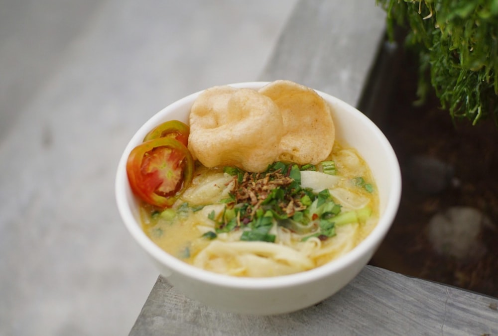 a bowl of soup with a piece of bread on top of it