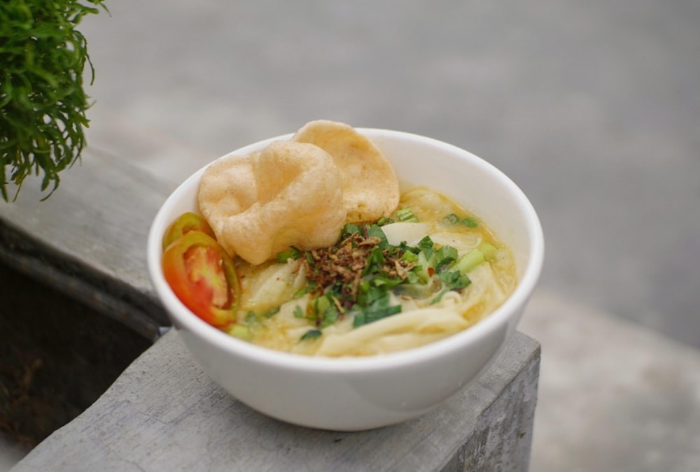 a bowl of food with a plant in the background