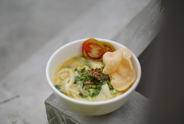 A bowl of soup with a side of chips