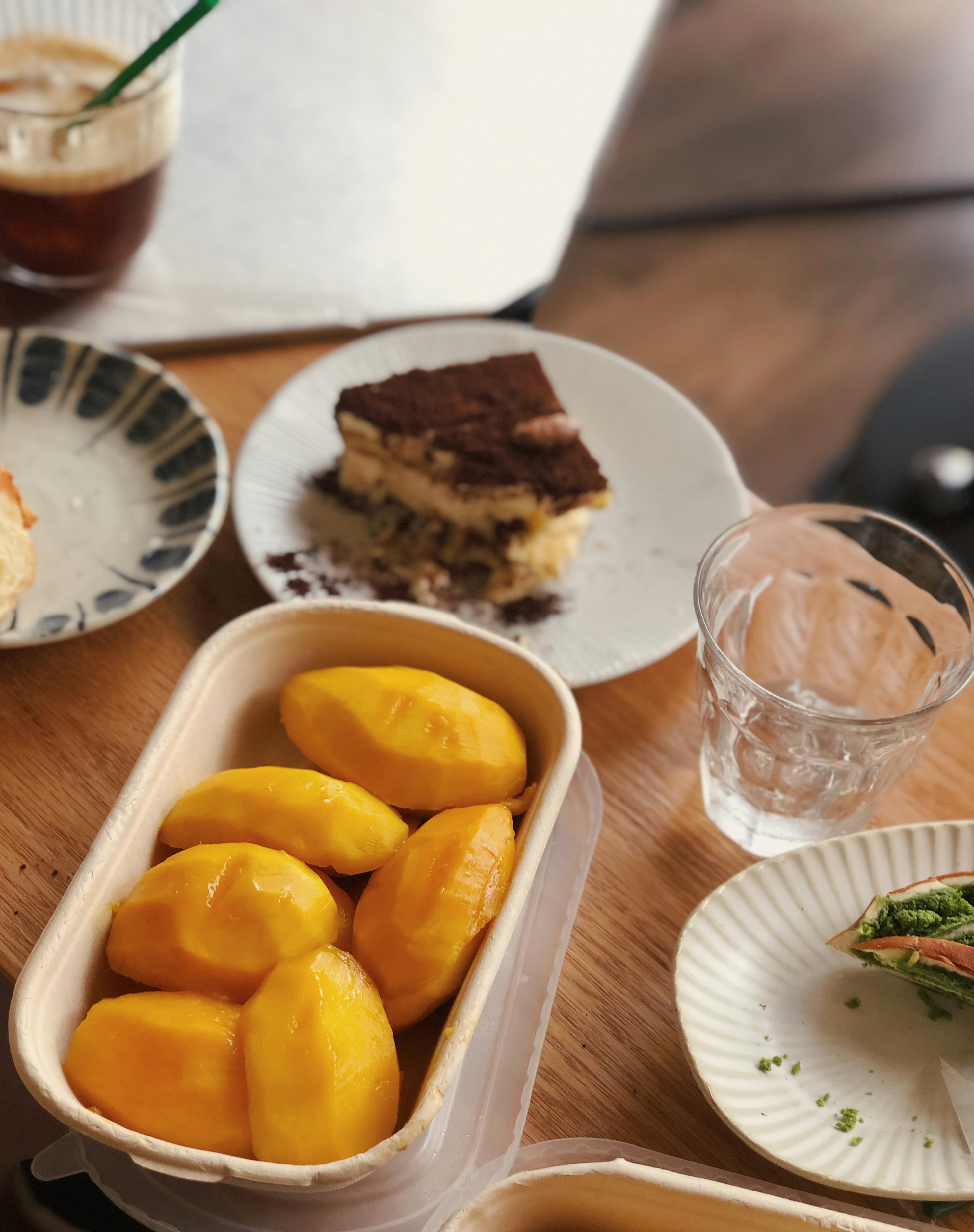 a wooden table topped with plates of food and drinks