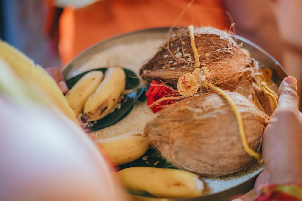 a person holding a plate of food with bananas