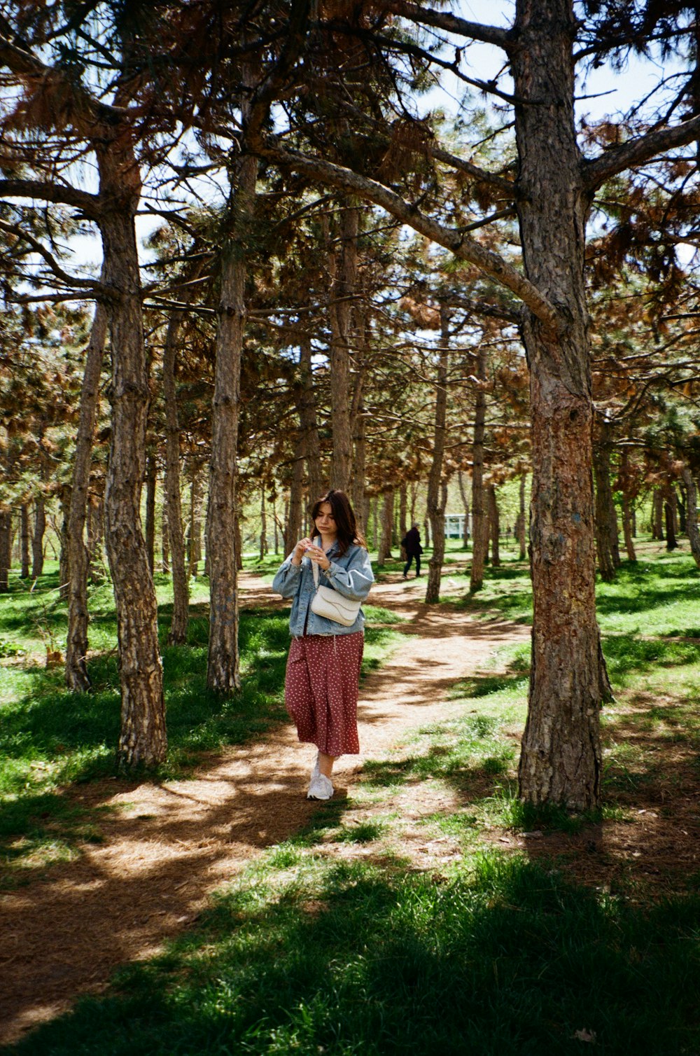 a woman standing in the middle of a forest