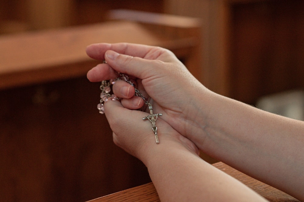 una persona sosteniendo un rosario en sus manos