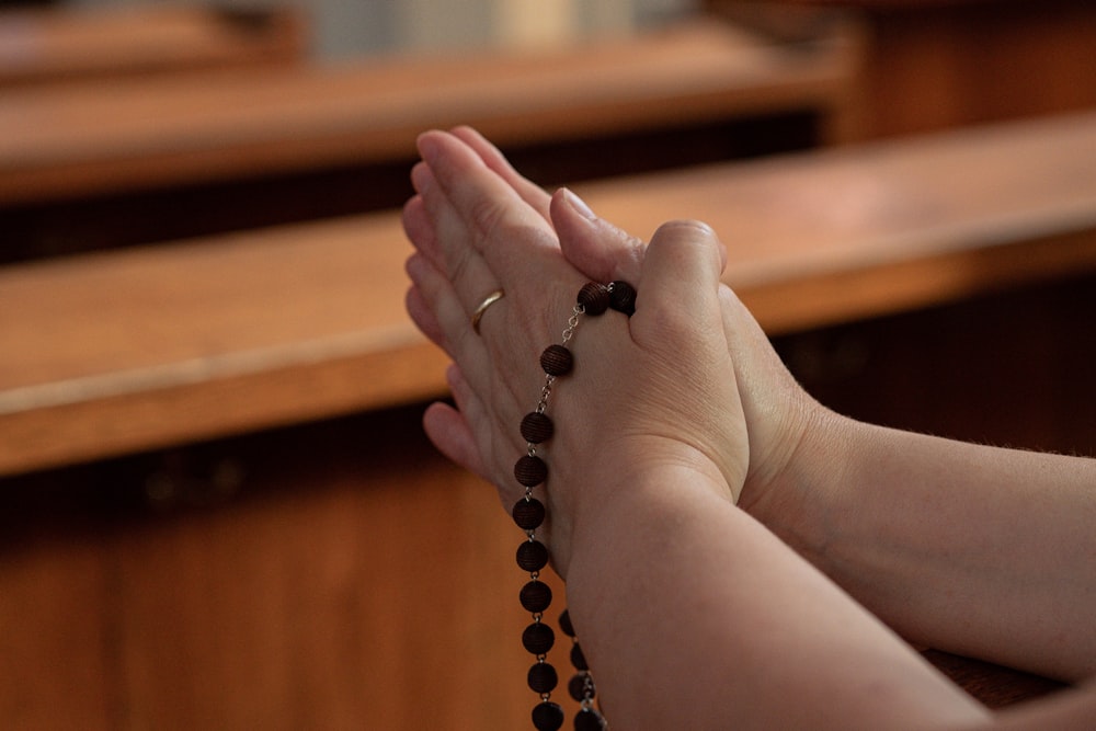 a woman holding her hands together in prayer