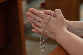 a woman holding a rosary in her hands