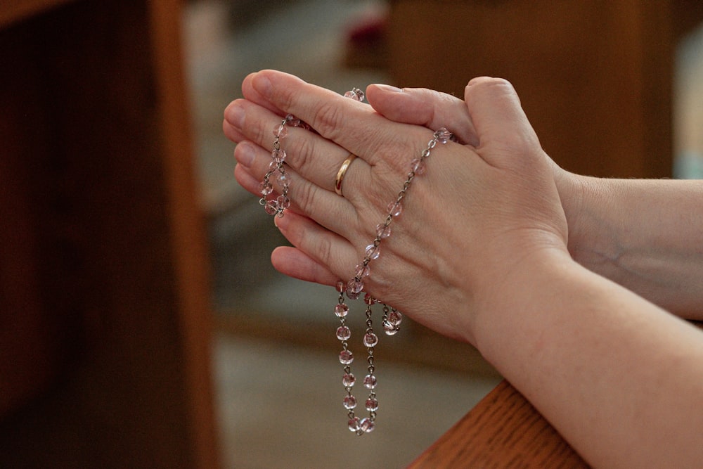 a woman holding a rosary in her hands