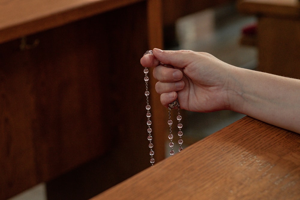 a person holding a rosary in their hand