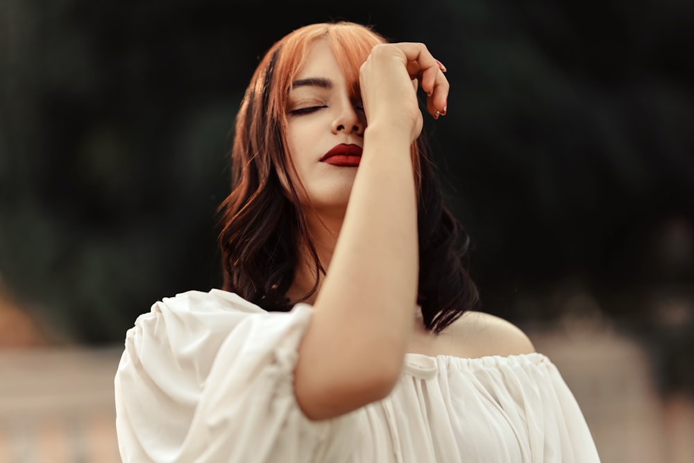 a woman in a white dress with her eyes closed