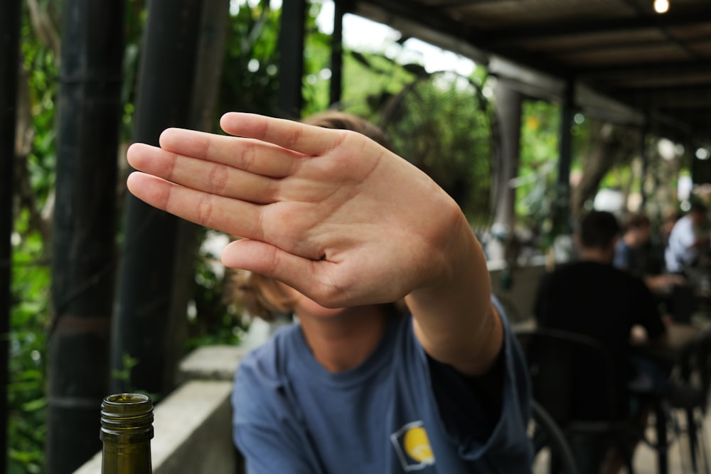 a man holding his hand up to the camera