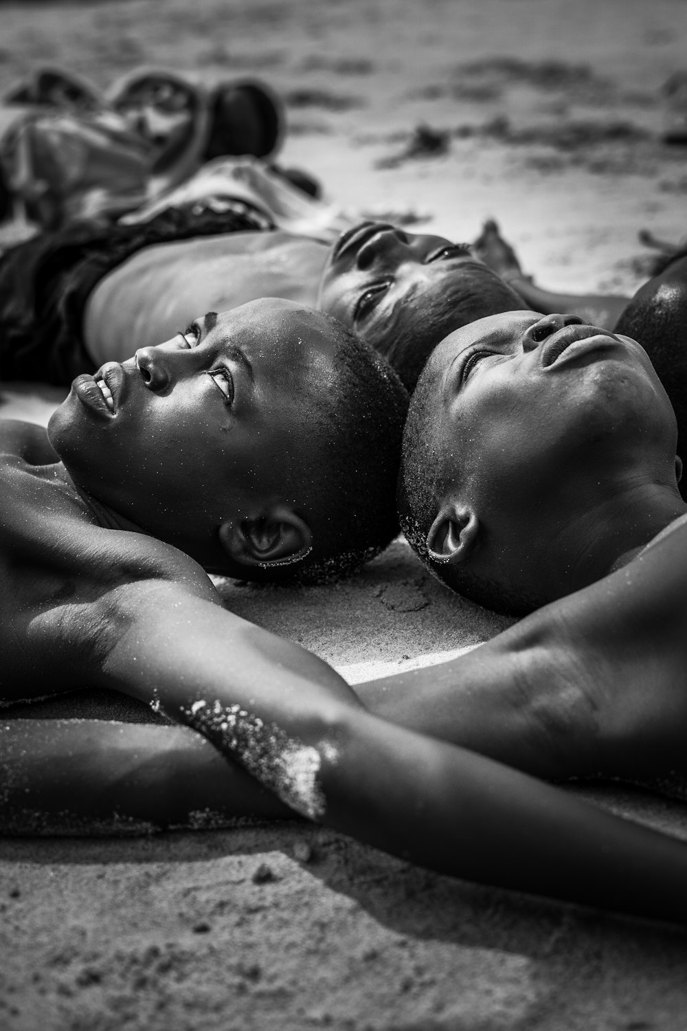 a group of people laying on top of a sandy beach