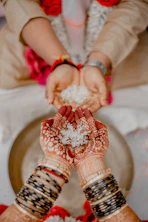 Hands holding rice during a traditional indian wedding ceremony.