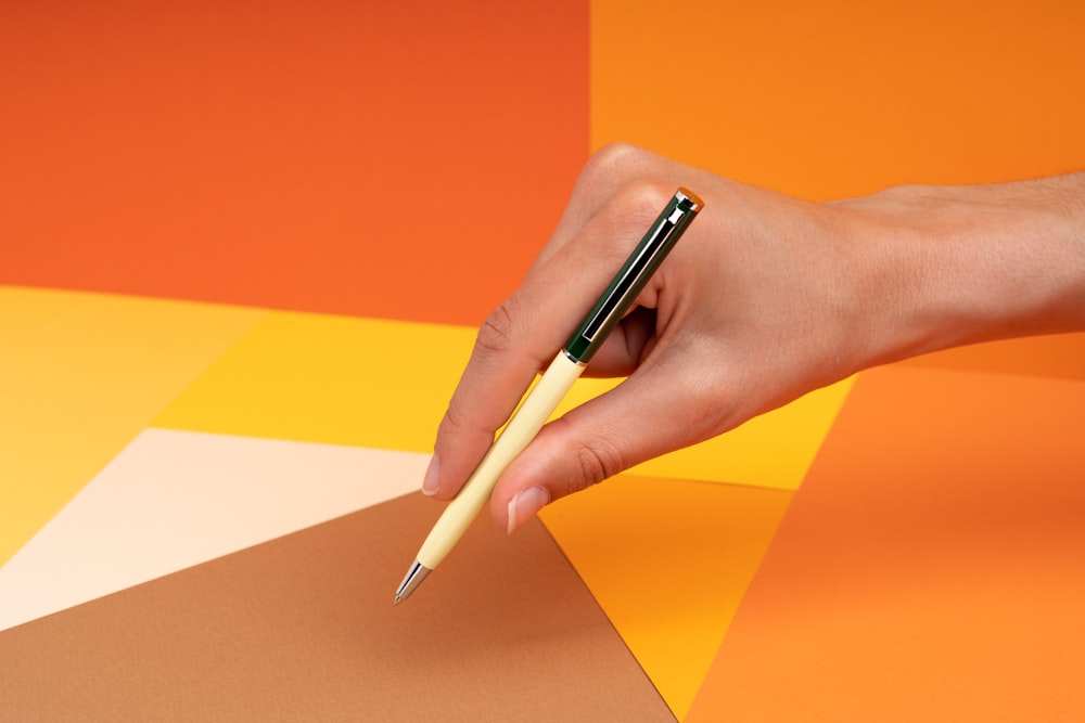 Die Hand einer Person, die einen Stift über ein Blatt Papier hält