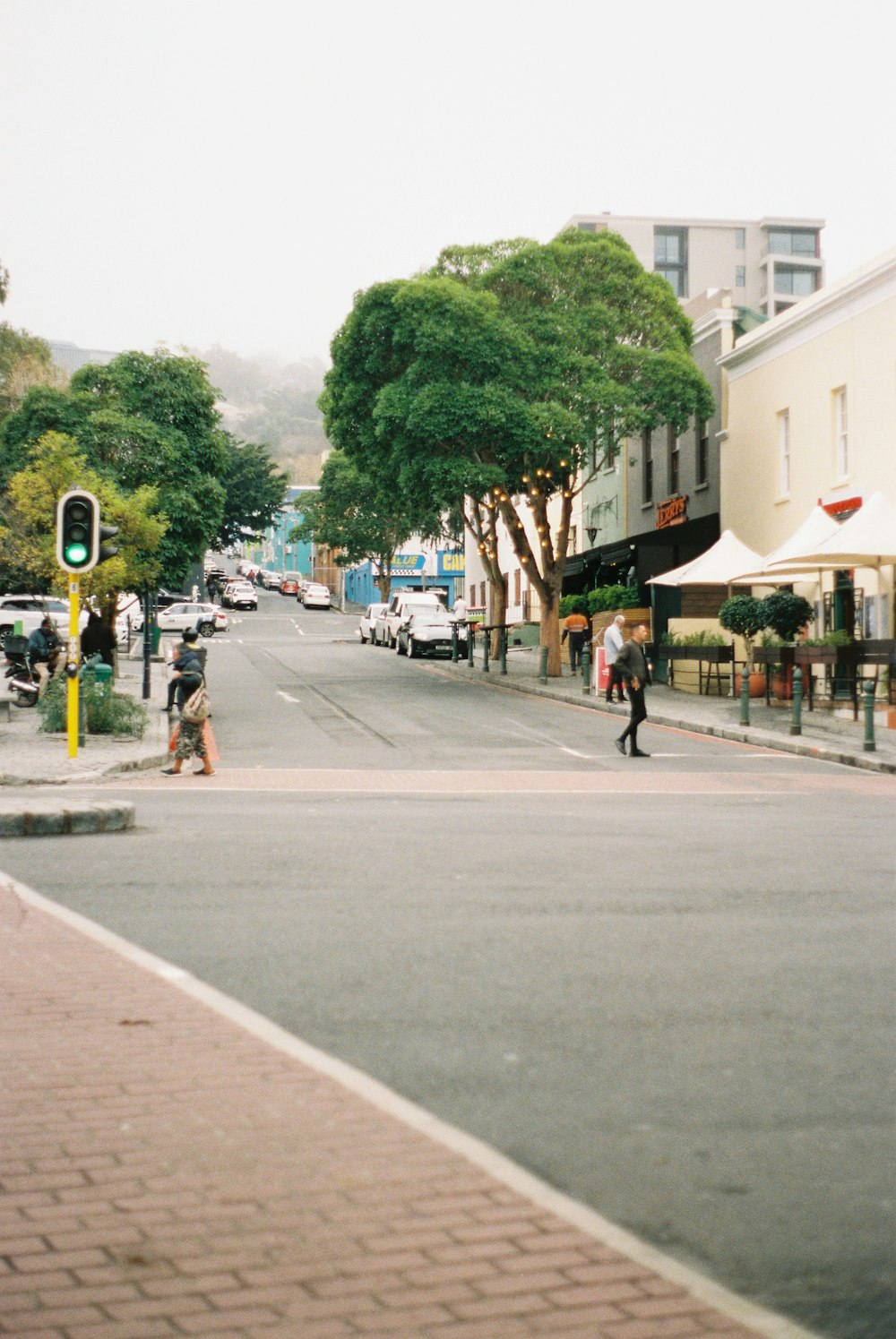 a street scene with people walking on the sidewalk