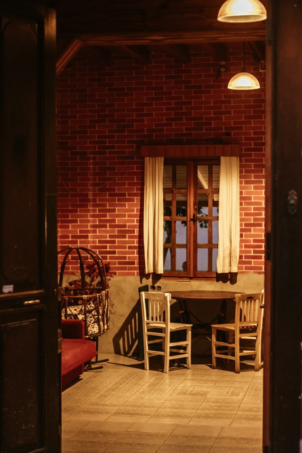 a room with a brick wall and a table and chairs