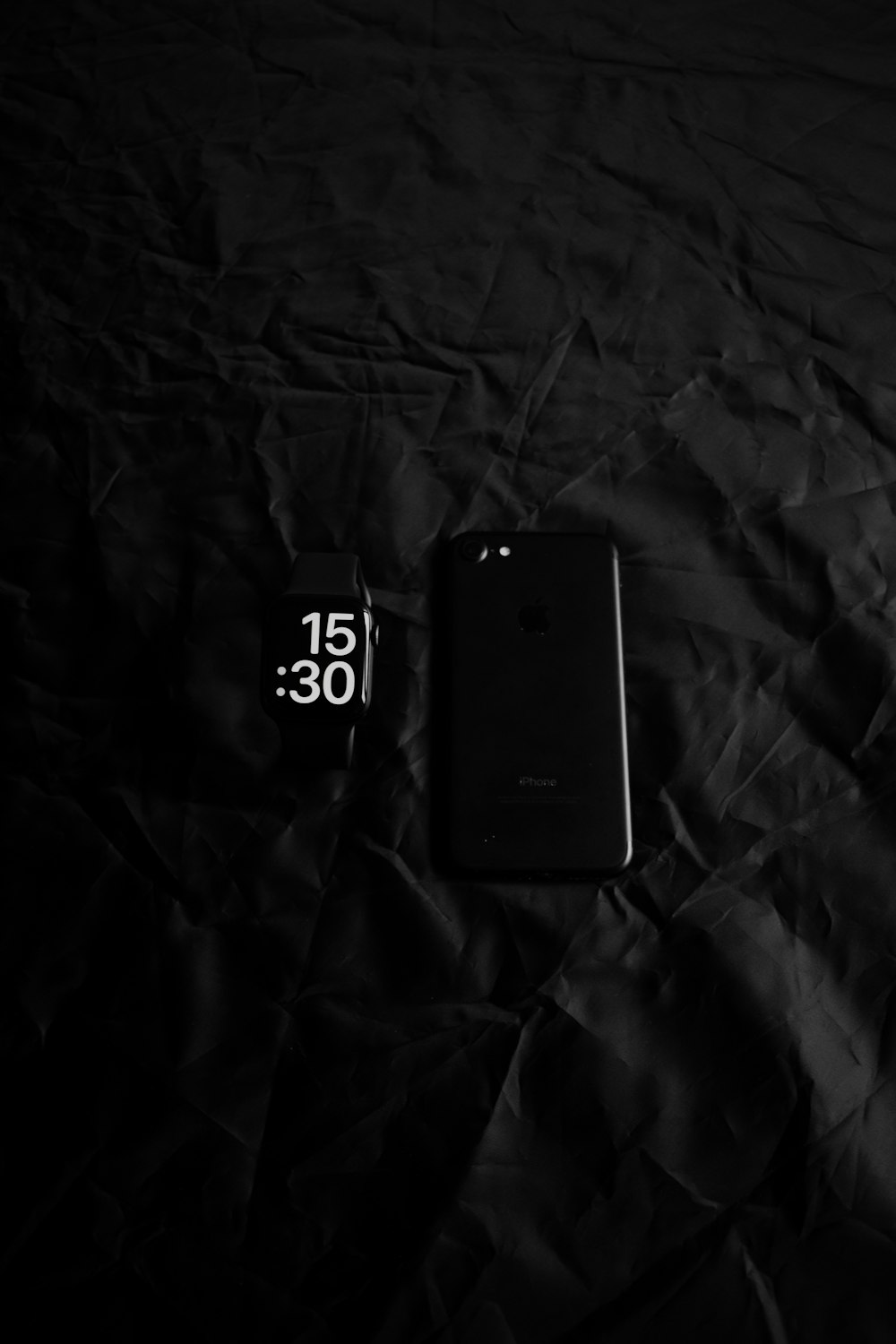 a cell phone laying on top of a black sheet