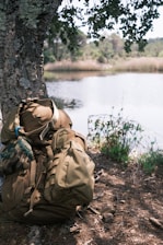 a backpack sitting on the ground next to a tree