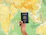 a hand holding a passport over a map