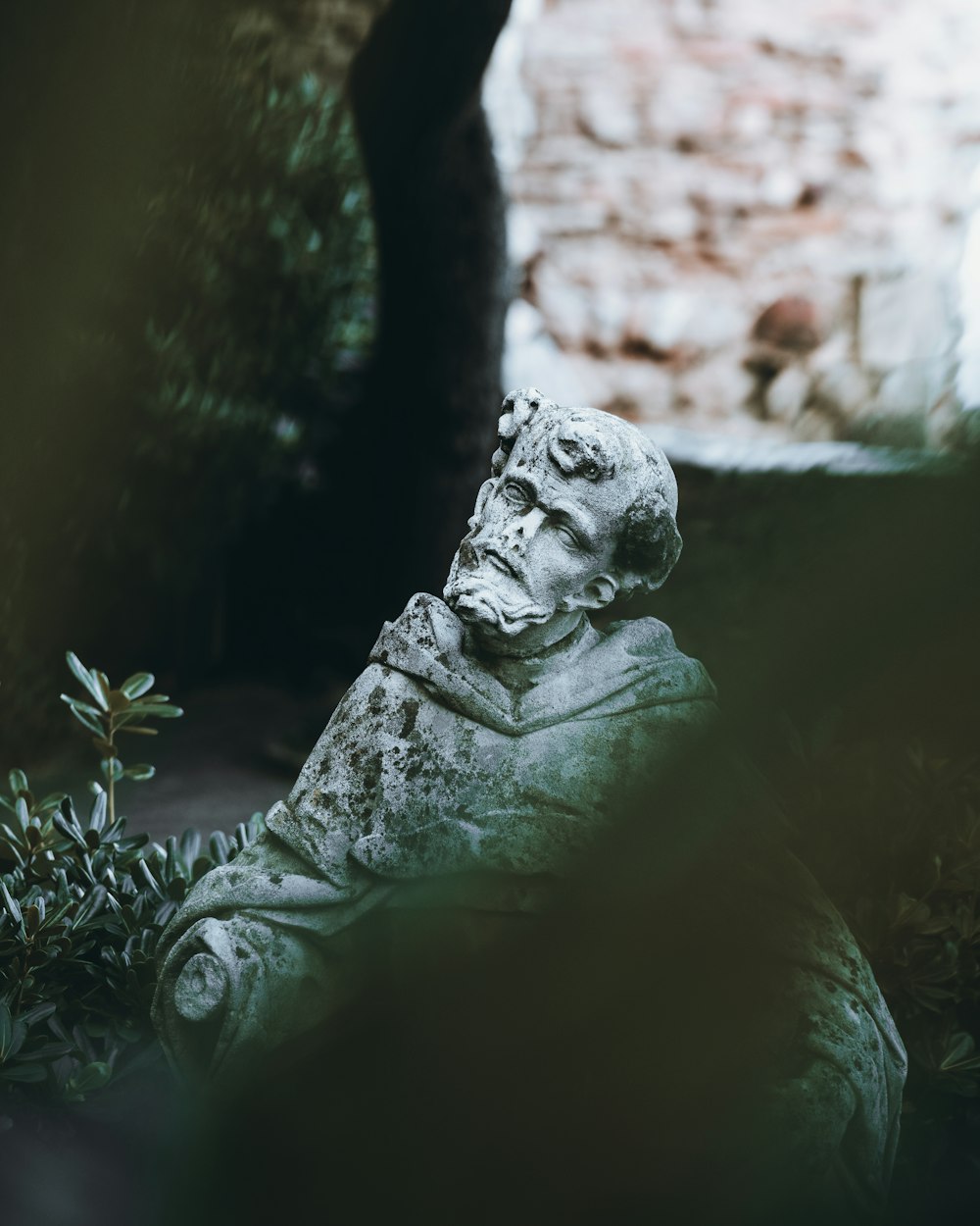 a statue of a man sitting in a garden