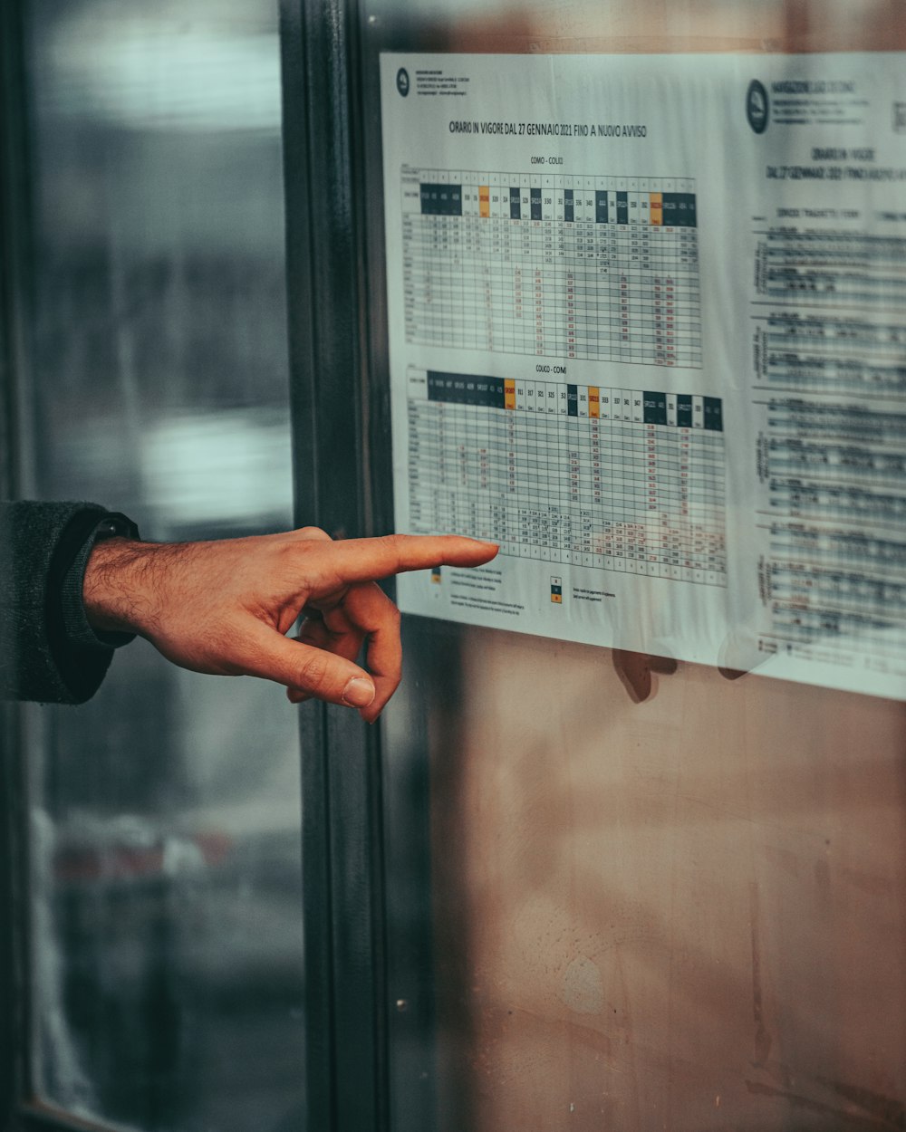 a person pointing at a poster on a wall