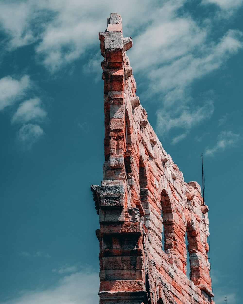 a very tall brick tower with a clock on it's side