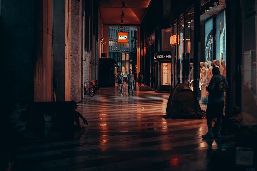 a group of people walking down a street at night