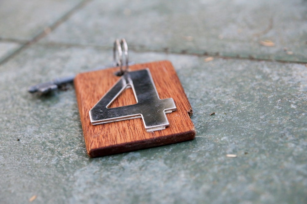 a wooden keychain with a metal letter on it