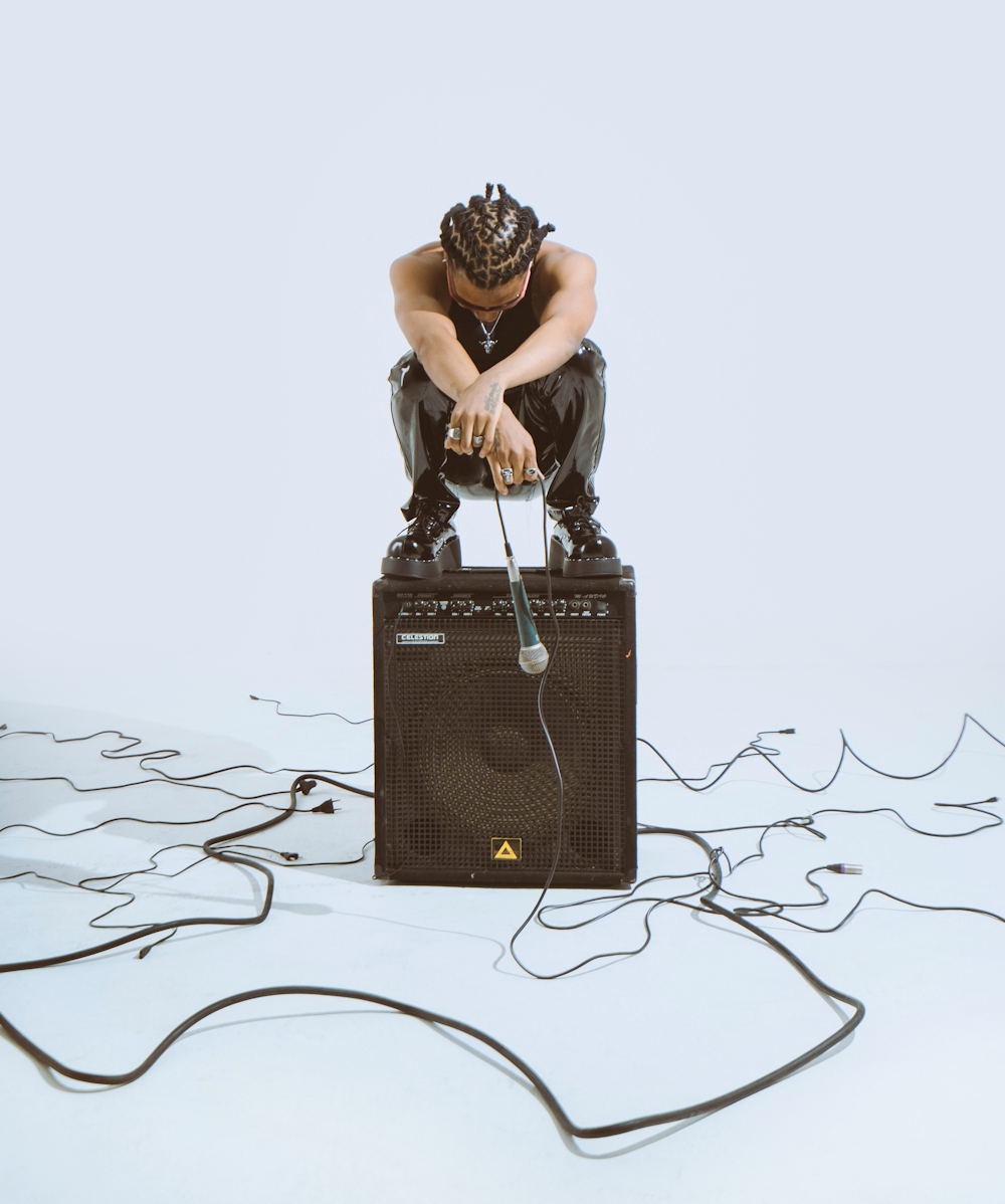a man sitting on top of an amp