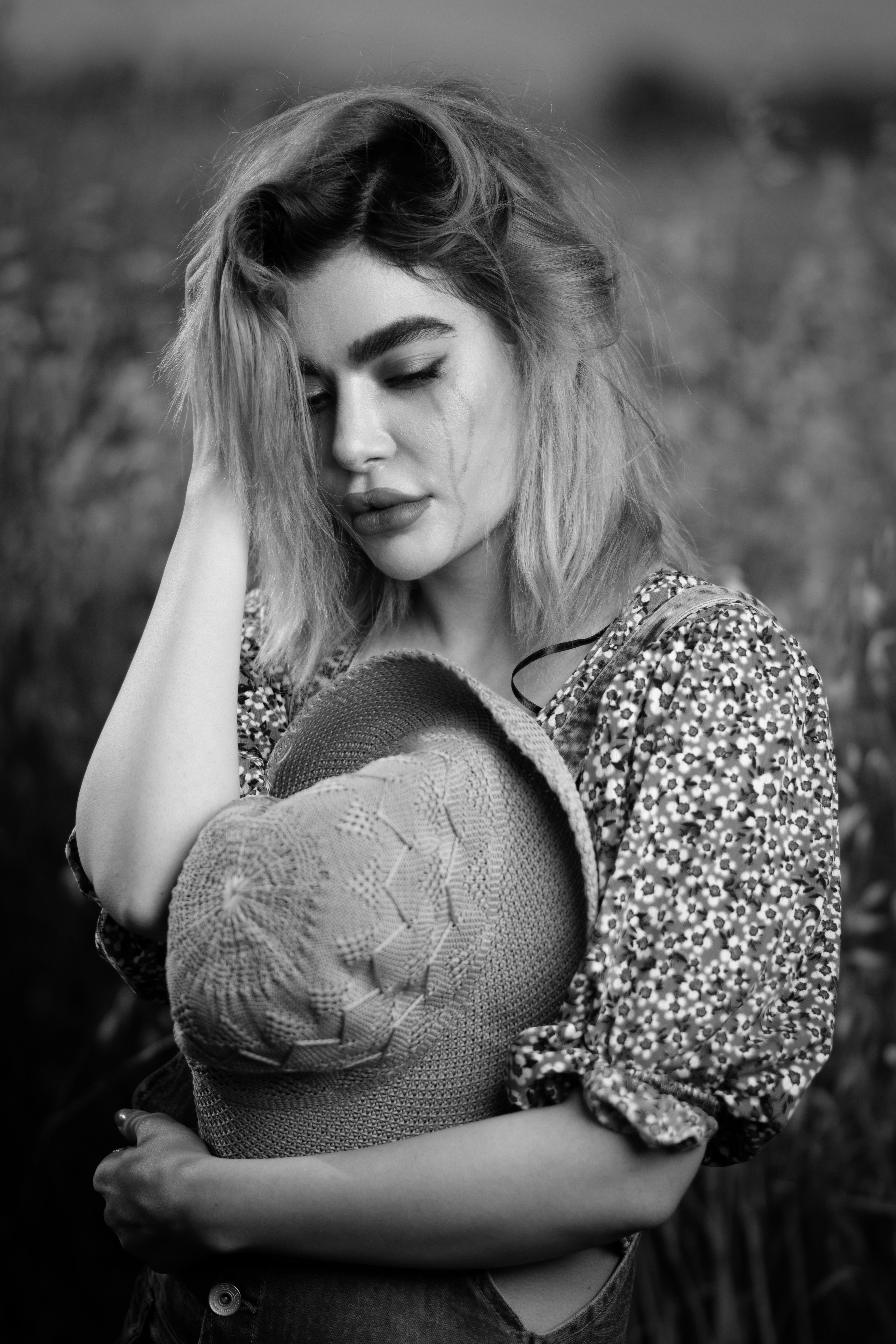 Une femme debout dans un champ, les mains sur la tête