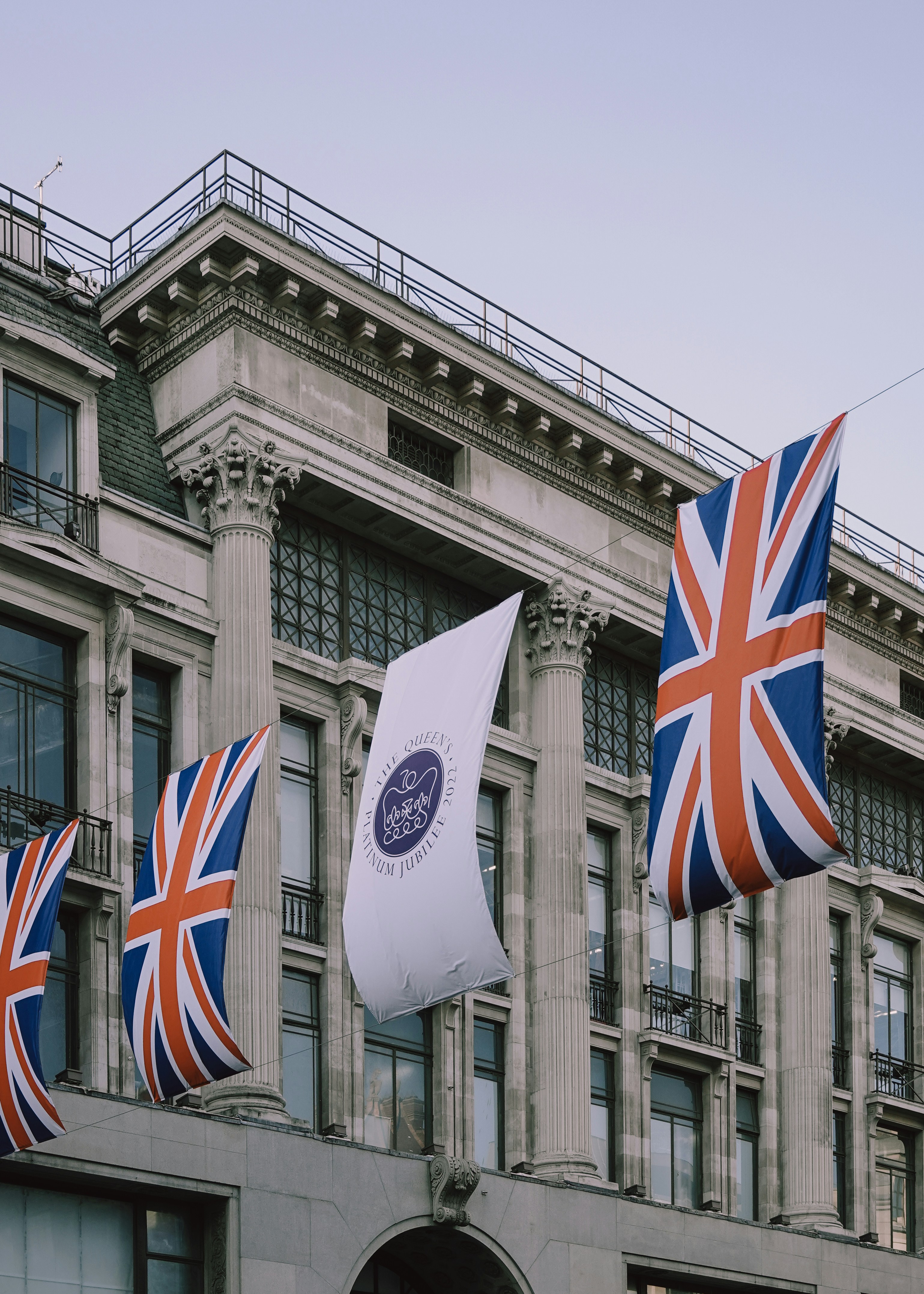 a group of flags flying in front of a building