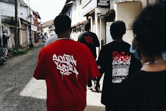 a group of people walking down a street wearing oversized printed cotton t-shirt